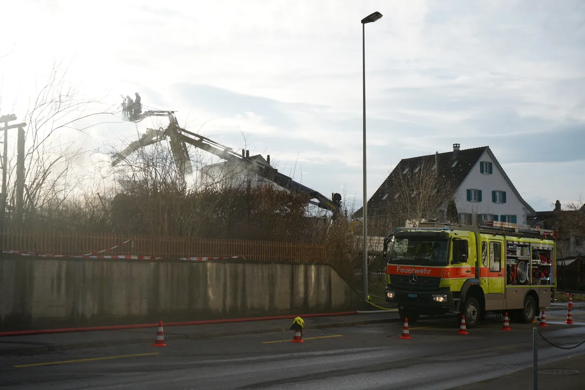 Ein Feuerwehrauto neben einer Einsatzstelle.